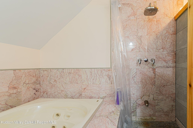 bathroom with separate shower and tub, vaulted ceiling, and tile walls