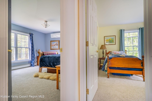 bedroom featuring light colored carpet, an AC wall unit, baseboard heating, and multiple windows