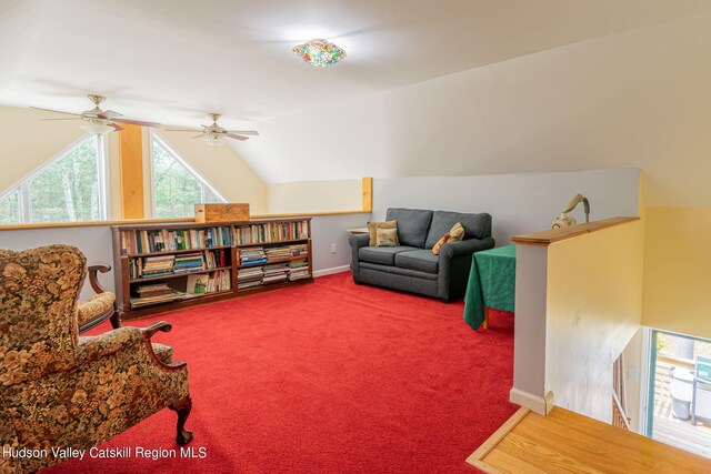 living area with carpet flooring, ceiling fan, and vaulted ceiling