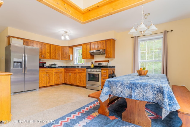 kitchen with a notable chandelier, a healthy amount of sunlight, decorative light fixtures, and appliances with stainless steel finishes