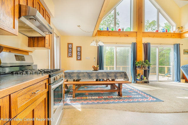 kitchen featuring stainless steel gas stove, high vaulted ceiling, a notable chandelier, carpet floors, and exhaust hood