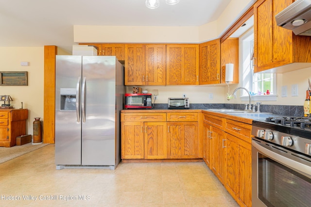 kitchen with appliances with stainless steel finishes, sink, and exhaust hood