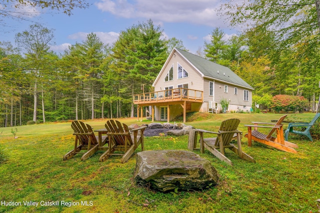 rear view of property with a lawn and a deck