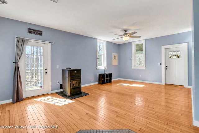 unfurnished living room with baseboards, a ceiling fan, and light wood-style floors