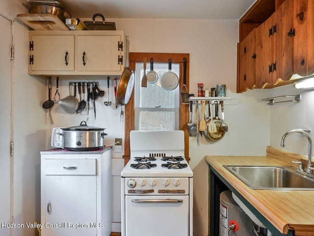 kitchen featuring sink, white cabinets, white stove, and wood counters