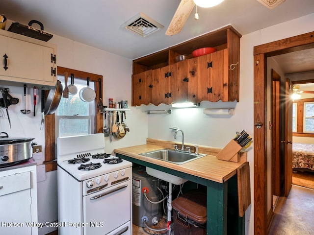 kitchen featuring ceiling fan, sink, and white stove