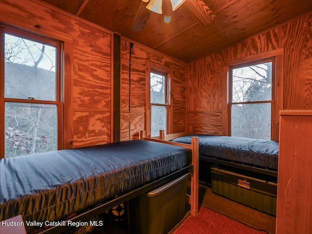 bedroom with carpet flooring, ceiling fan, wooden ceiling, and multiple windows