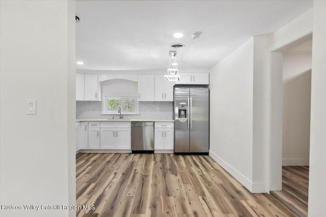 603-607 Old Stage Rd, Saugerties, NY 12477 - kitchen featuring stainless steel appliances, light wood-style flooring, white cabinets, a sink, and light countertops