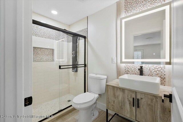 603-607 Old Stage Rd, Saugerties, NY 12477 - bathroom featuring toilet, a shower stall, vanity, decorative backsplash, and wood finished floors