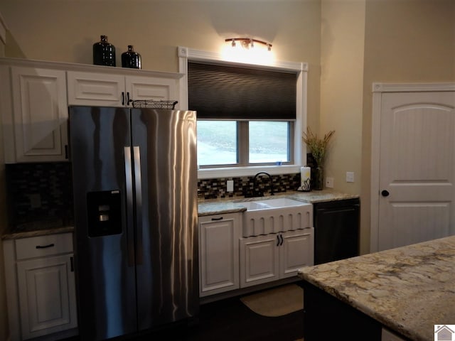 kitchen with white cabinets, backsplash, light stone counters, and stainless steel refrigerator with ice dispenser