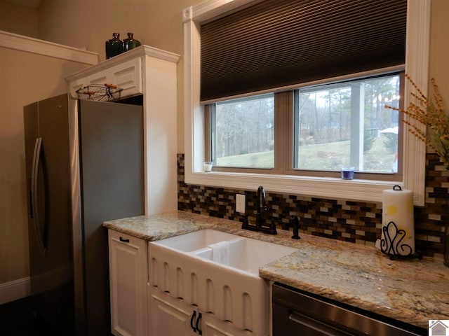 kitchen featuring white cabinets, a wealth of natural light, appliances with stainless steel finishes, and tasteful backsplash