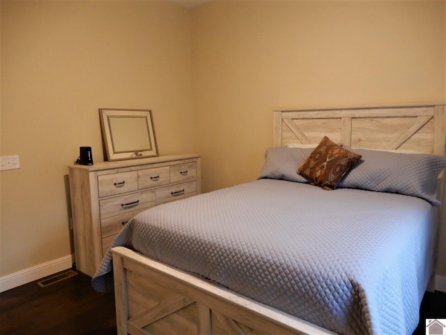 bedroom with dark hardwood / wood-style floors