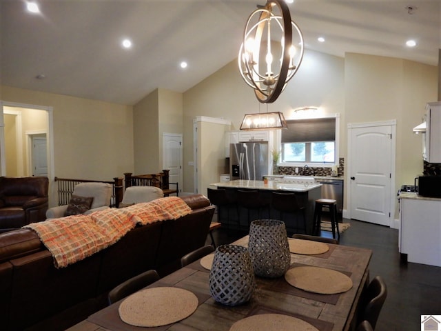 dining room with dark hardwood / wood-style flooring, high vaulted ceiling, and a chandelier