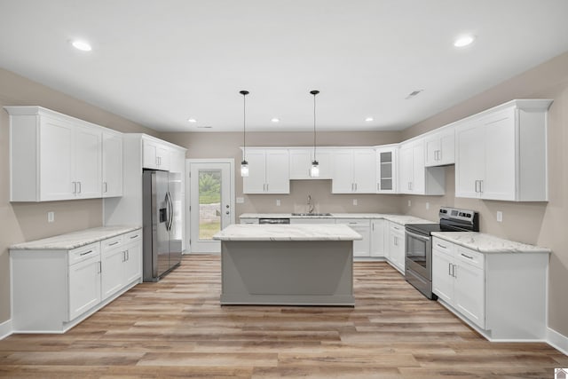 kitchen with decorative light fixtures, white cabinets, a center island, and stainless steel appliances