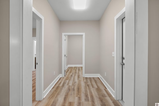 corridor with light hardwood / wood-style floors