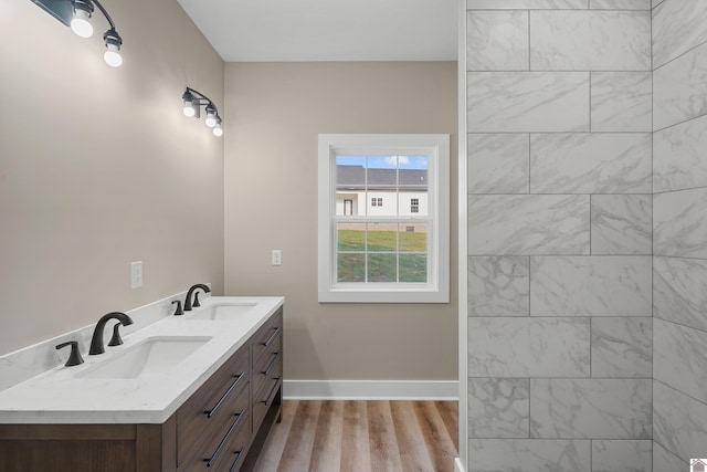 bathroom with hardwood / wood-style floors and dual vanity