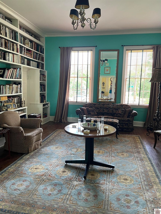 living room with dark hardwood / wood-style flooring, a notable chandelier, built in shelves, and a wealth of natural light