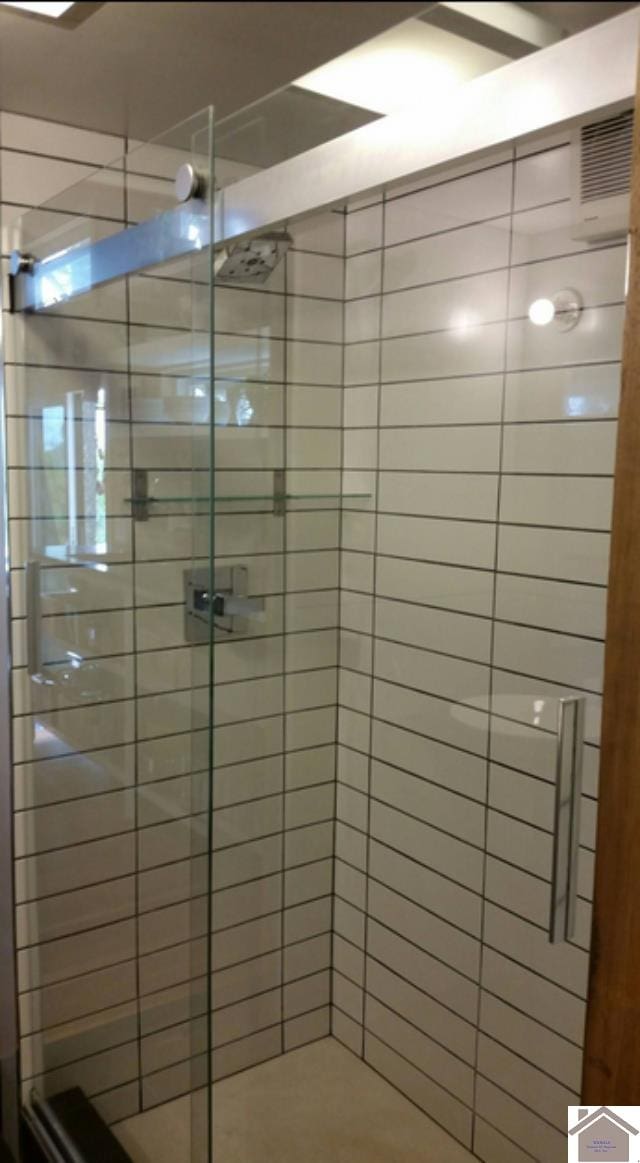 bathroom featuring a shower with door