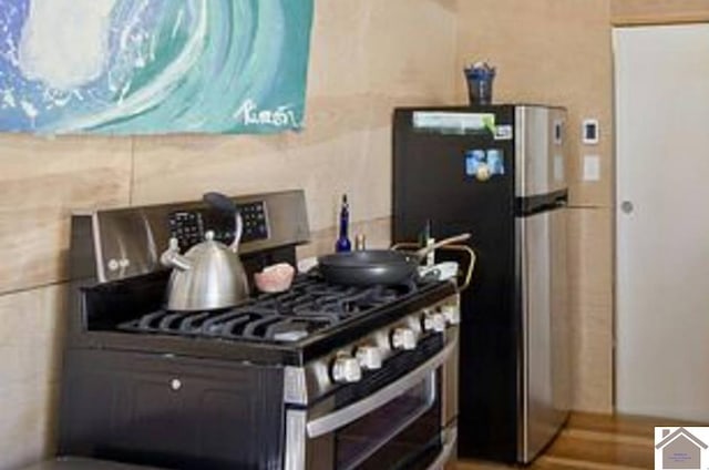 kitchen with appliances with stainless steel finishes and wood-type flooring