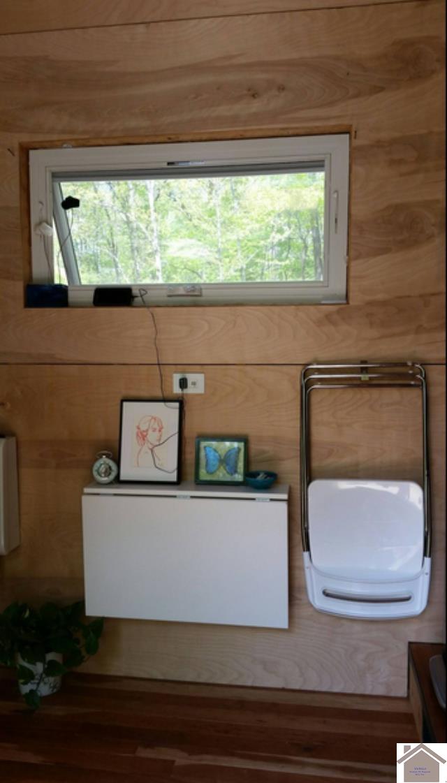 bathroom featuring wooden walls, a healthy amount of sunlight, and hardwood / wood-style floors