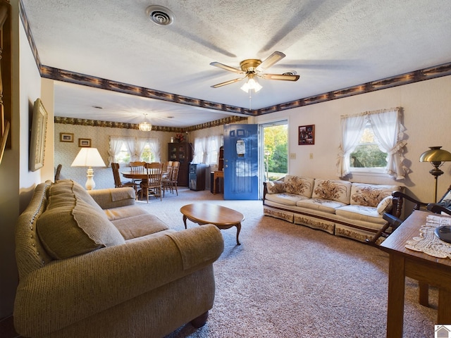 living room with a textured ceiling, light colored carpet, and ceiling fan