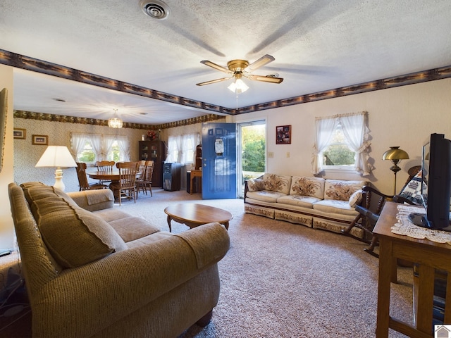 living room with ceiling fan, carpet flooring, a textured ceiling, and a healthy amount of sunlight