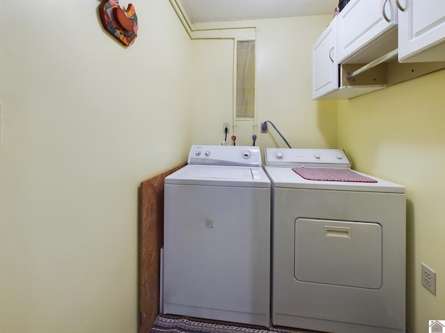 clothes washing area featuring independent washer and dryer and cabinets