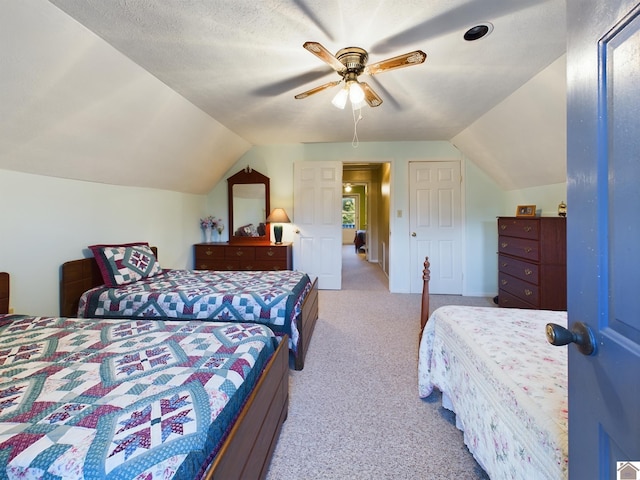 carpeted bedroom with ceiling fan, lofted ceiling, and a textured ceiling