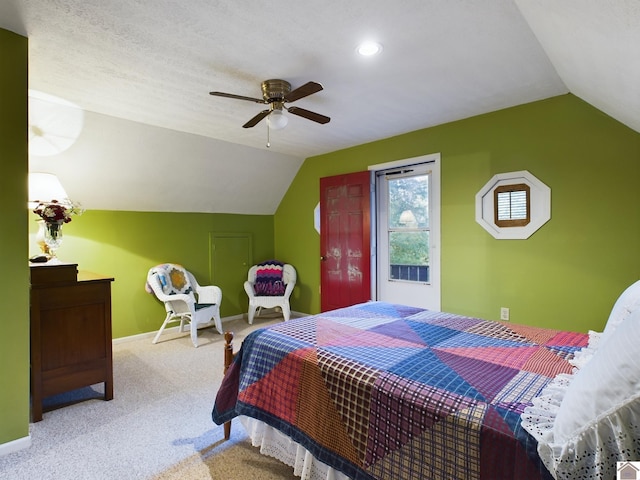 bedroom with ceiling fan, lofted ceiling, light colored carpet, and a textured ceiling