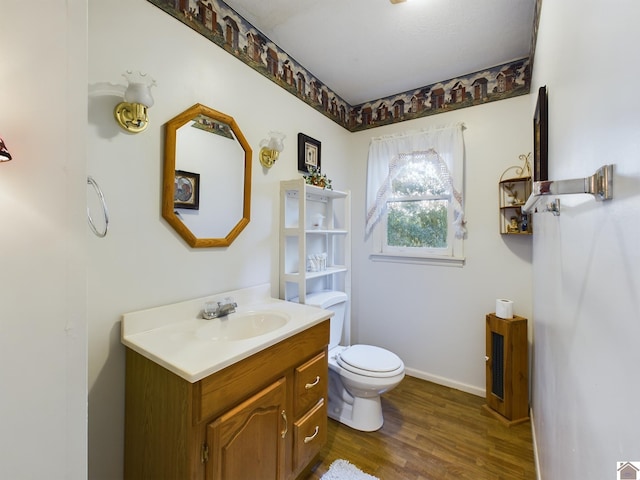 bathroom featuring hardwood / wood-style floors, toilet, and oversized vanity