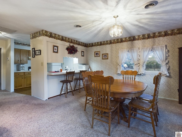 dining area featuring a chandelier and carpet