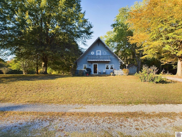 view of front of house featuring a storage shed and a front yard