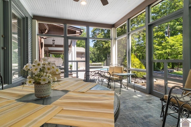 sunroom / solarium featuring plenty of natural light and ceiling fan