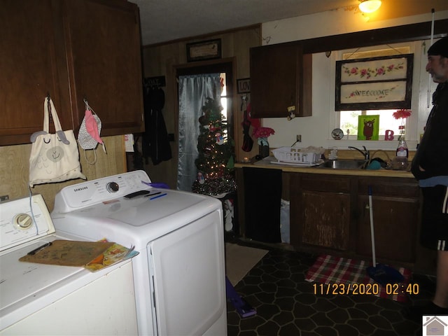 clothes washing area with washing machine and clothes dryer and sink
