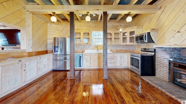 kitchen with appliances with stainless steel finishes, white cabinetry, pendant lighting, and dark wood-type flooring