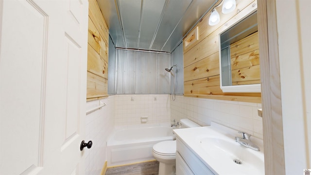 bathroom featuring toilet, large vanity, hardwood / wood-style floors, and tile walls