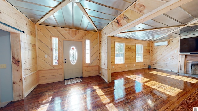 entrance foyer featuring plenty of natural light, dark hardwood / wood-style floors, a fireplace, and wood walls