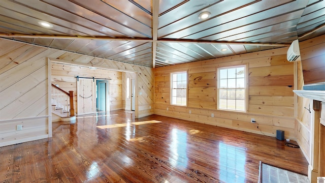 spare room with a barn door, vaulted ceiling, and dark hardwood / wood-style floors