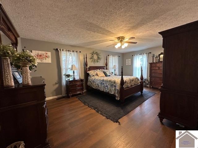 bedroom featuring dark hardwood / wood-style flooring, a textured ceiling, and ceiling fan