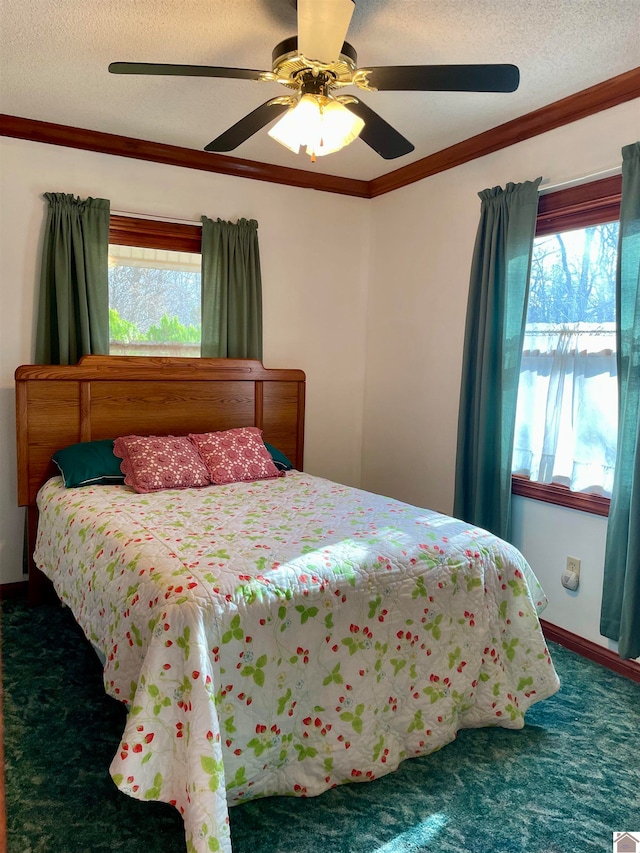 bedroom featuring ceiling fan, a textured ceiling, multiple windows, and carpet flooring