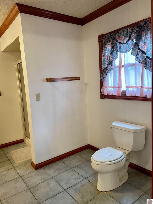 bathroom with tile flooring, a shower with shower door, crown molding, and toilet