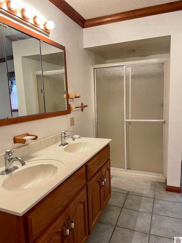 bathroom with crown molding, a shower with shower door, tile floors, dual vanity, and a textured ceiling