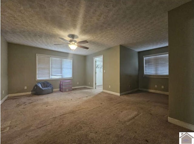 spare room featuring ceiling fan and dark carpet