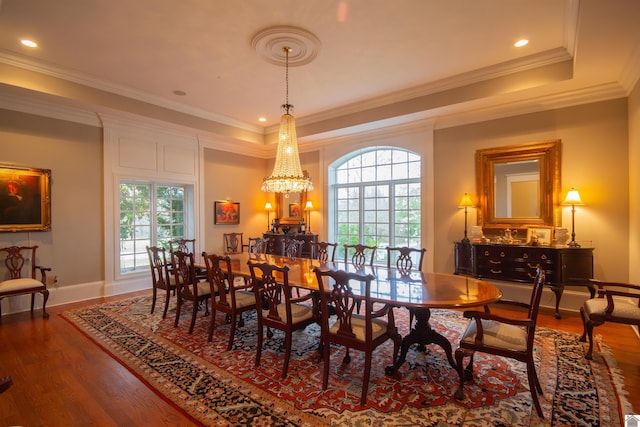 dining space with dark hardwood / wood-style flooring, a notable chandelier, crown molding, and a tray ceiling