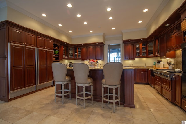 kitchen featuring a kitchen breakfast bar, light stone countertops, a center island, and light tile floors