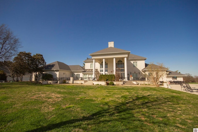 back of house featuring a lawn and a patio