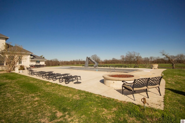 view of home's community with a fire pit, a lawn, and a patio area