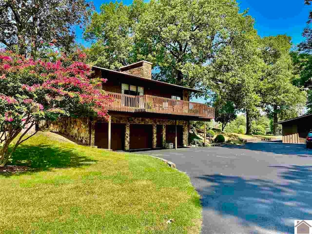 view of front of house featuring a front yard and a balcony