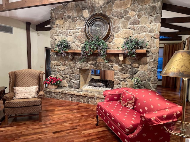 sitting room with a fireplace, dark hardwood / wood-style floors, and beamed ceiling