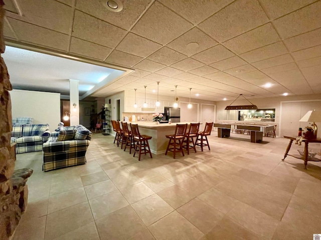 dining room featuring light tile floors and a drop ceiling